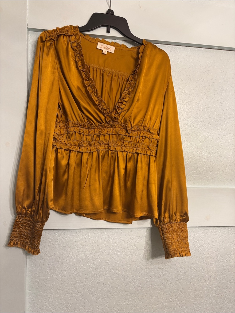 Gold V-neck ruffled neckline. High ruffled bodice. Cuffed elastic banded.